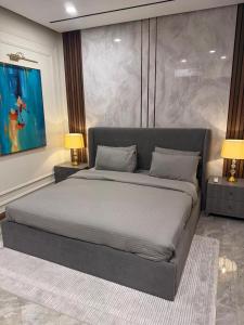 a large bed in a bedroom with two lamps at Emanzara in Islamabad