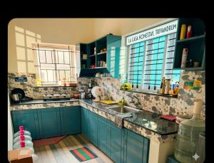 a kitchen with blue cabinets and a sink at LA CASA THE HOMESTAY in Trivandrum