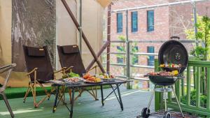 a table with food and a grill on a balcony at Pocheon Terrace 527 Campground in Pocheon