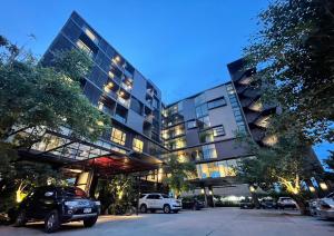 a large building with cars parked in a parking lot at Sibtis Hotel in Lampang