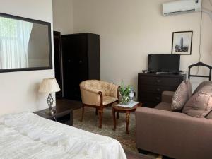 ein Schlafzimmer mit einem Bett, einer Couch und einem Stuhl in der Unterkunft Hotel KREZ in Qysylorda