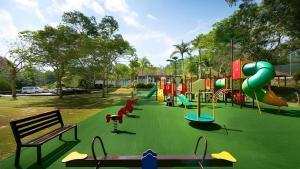 a park with a playground with a slide and benches at Damai Laut Serene Stay Studio Lumut in Lumut