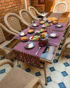 a wooden table with plates of food on it at Shahina in Samarkand