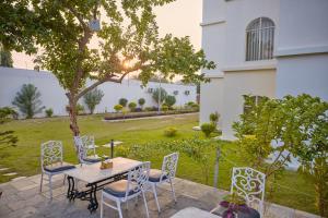 a patio with a table and chairs and a yard at Mithila Yatri Niwas in Janakpur