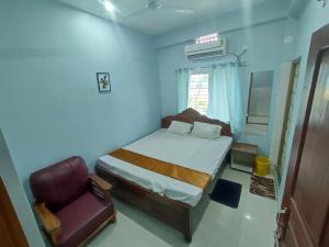a small bedroom with a bed and a chair at Hotel Namaste Katihar INN in Katihār