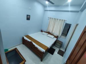 a small bedroom with a bed and a television at Hotel Namaste Katihar INN in Katihār