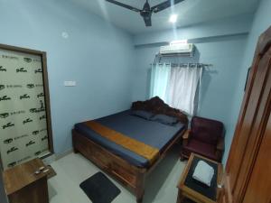 a bedroom with a bed and a chair in it at Hotel Namaste Katihar INN in Katihār