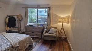 a bedroom with a bed and a chair and a window at Beachside Bungalow in Minnie Water