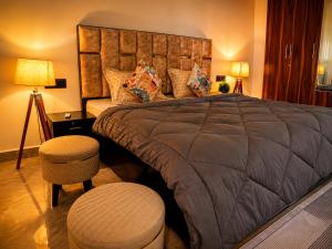 a bedroom with a large bed and a table and stool at Cozy and Tranquil nest with wifi and homely care in Greater Noida +51 photos