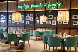a dining room with tables and chairs and a neon sign at INNSiDE by Meliá Liverpool in Liverpool
