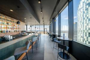a restaurant with a bar with a view of the city at INNSiDE by Meliá Liverpool in Liverpool
