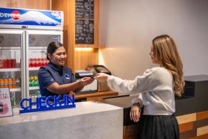 two women standing at a cash register in a store at Kokotel Cebu Adira in Cebu City