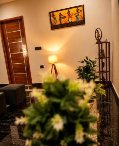 a living room with a lamp and flowers in a room at Cozy and Tranquil nest with wifi and homely care in Greater Noida