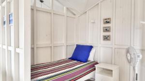 a room with a bench with a blue pillow on it at Jack s Cottage in Wooli