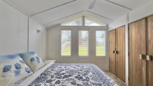 a bedroom with a bed with blue and white pillows at Jack s Cottage in Wooli