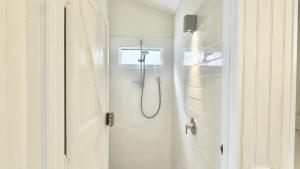a bathroom with a shower with a shower curtain at Jack s Cottage in Wooli +12 photos