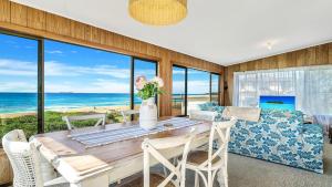 a dining room with a table with a view of the ocean at Kokomo in Wooli