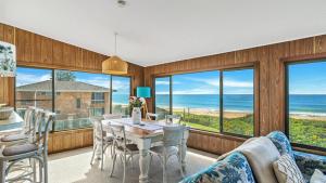 a dining room with a table and views of the ocean at Kokomo in Wooli