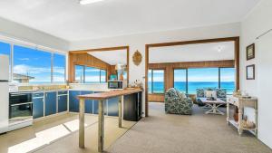 a kitchen with blue cabinets and a view of the ocean at Kokomo in Wooli