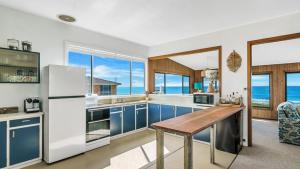 a kitchen with blue cabinets and a wooden table at Kokomo in Wooli +16 photos