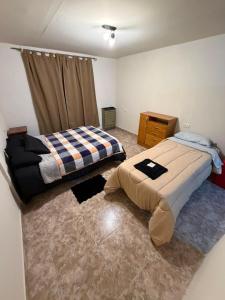 a bedroom with a bed and a dresser in it at La Cumbre in Chos Malal