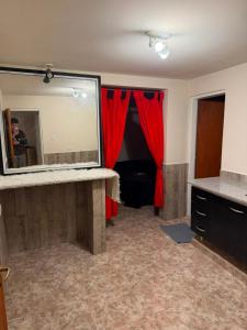 a bathroom with a large mirror and a red curtain at La Cumbre in Chos Malal
