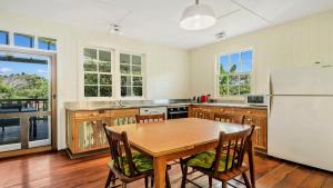 a kitchen with a wooden table and a white refrigerator at Moomba On Main in Wooli +13 photos