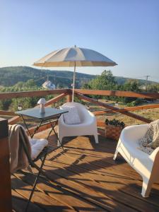 a patio with a table and chairs and an umbrella at Lombfészek in Rezi