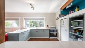 a kitchen with white cabinets and a window at Wooli House in Wooli