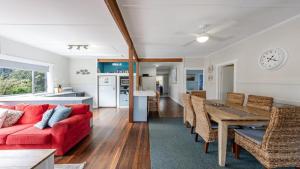 a living room with a red couch and a table at Wooli House in Wooli