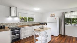 a kitchen with white appliances and a white refrigerator at Twin Palms Retreat in Wooli