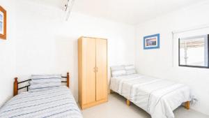 two beds in a room with white walls at Twin Palms Retreat in Wooli +15 photos