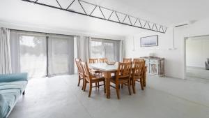 a dining room with a table and chairs and a couch at Twin Palms Retreat in Wooli
