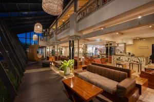 a lobby with couches and tables in a building at Natural Park Resort Pattaya in Jomtien Beach