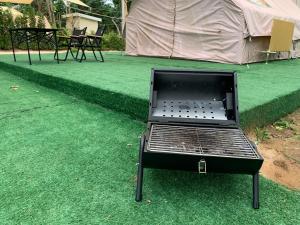 an oven sitting on top of a green lawn at Riverside Glamping Resort Kanchanaburi in Kanchanaburi City