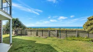 a house with a fence and a view of the ocean at The Peninsula Wooli in Wooli