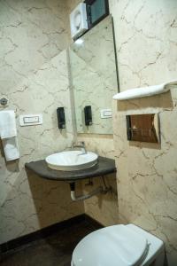 a bathroom with a sink and a toilet and a mirror at Hotel CP Residency in Agra
