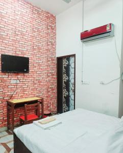 a room with a bed and a brick wall at Hotel CP Residency in Agra