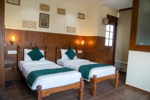 two twin beds in a room with at Hotel CP Residency in Agra