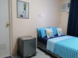 a small room with a bed with blue pillows at Solsken Guest House - Bantayan Island in Bantayan Island