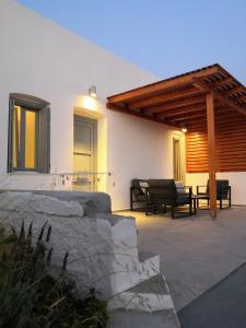 a patio with a couch and a wooden pergola at Haroto Suites in Tripiti
