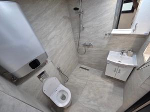 a bathroom with a shower and a toilet and a sink at Fragma in Targovishte