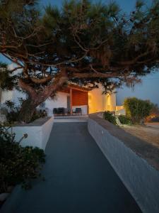 a pathway leading to a house with a tree at Haroto Suites in Tripiti