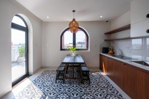 a kitchen with a table on a tile floor at Cactus Villa in Dong Hoi