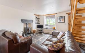 a living room with a leather couch and a fireplace at 2 Bed in Ambleside oc-lr059 in Ambleside