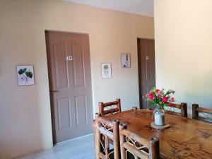 a dining room table with a vase of flowers on it at Solsken Guest House - Bantayan Island in Bantayan Island