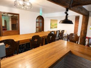 a conference room with a large wooden table and chairs at Maple House Backpackers in Iiyama