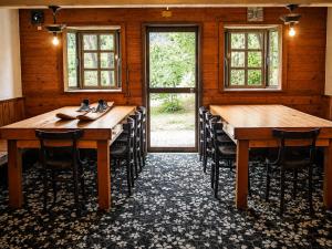 a room with two wooden tables and chairs in it at Maple House Backpackers in Iiyama
