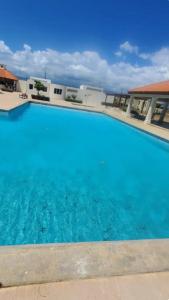 a large blue swimming pool in front of a building at The Grand suite in Portmore