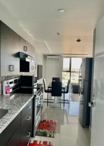 a kitchen with a refrigerator and a table with chairs at The Grand suite in Portmore